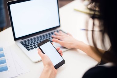 Cep telefonu ve laptop ofiste kullanarak kadının elleri