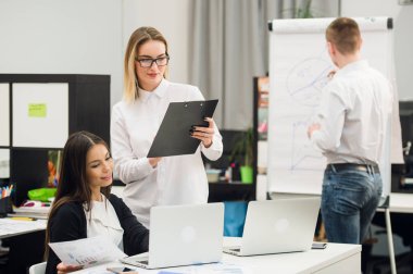 Güzel iş adamları kameraya bakıyor ve Office dururken gülümseyen