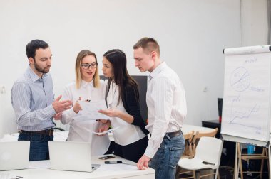 Grup dört farklı erkek ve kadınların Gündelik Giyim ofisinde konuşmak