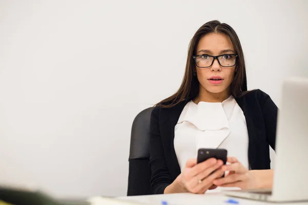 Primer plano retrato joven, mujer de negocios conmocionada, mirando el teléfono celular ver mal mensaje de texto, correo electrónico, aislado en interiores fondo de la oficina. Emociones negativas, expresiones faciales — Foto de Stock