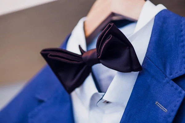 Close-up of blue jacket with bow tie on a hanger. — Stock Photo, Image