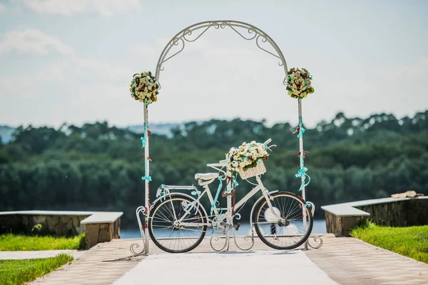 Arco branco e azul decorado com flores bicicleta, registro de casamento ao ar livre — Fotografia de Stock