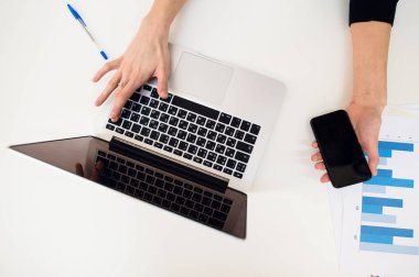 Laptop kadınlar el ve kağıt grafik üzerinde beyaz tablo ile.