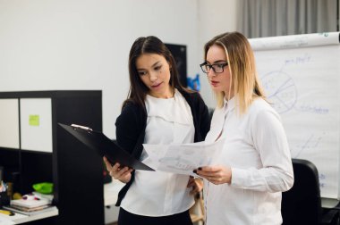 İki güzel genç Yöneticiler bazı belgeleri okuma