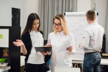 Konuşmayı adam meslektaşım iş stratejisi üzerinde flip grafik çizim sırasında iki güzel Ofis çalışanları.