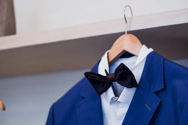 Close-up of blue jacket with bow tie on a hanger. — Stock Photo, Image