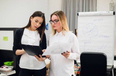 Konuşmayı adam meslektaşım iş stratejisi üzerinde flip grafik çizim sırasında iki güzel Ofis çalışanları.