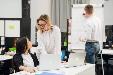 Konuşmayı adam meslektaşım iş stratejisi üzerinde flip grafik çizim sırasında iki güzel Ofis çalışanları.