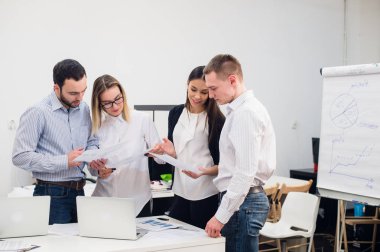 Grup dört farklı erkek ve kadınların Gündelik Giyim ofisinde konuşmak