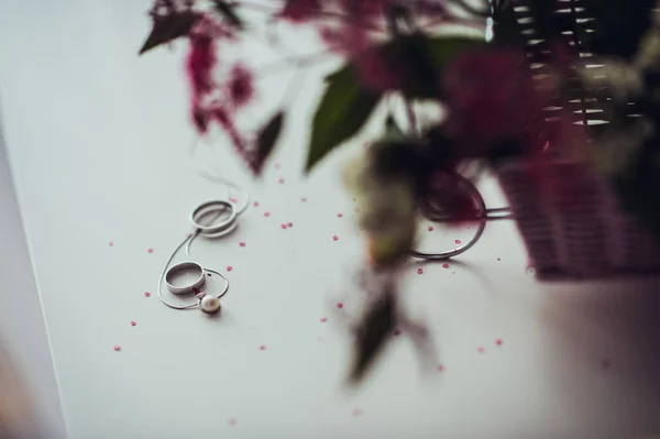 Brautstrauß und Ringe auf weißem Tisch — Stockfoto