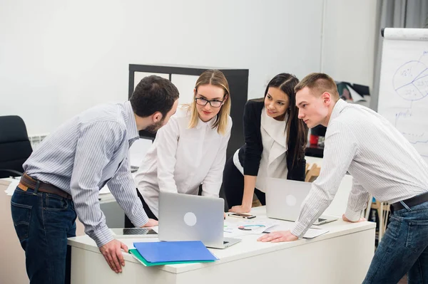 Młodych biznesmenów, siedząc w biurze, podczas spotkań i dyskusji z dokumentów za pomocą laptopów — Zdjęcie stockowe
