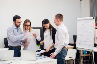 Beyin fırtınası. Zeki iş adamlarından oluşan neşeli bir grup dizüstü bilgisayara bakıp gülümsüyor.