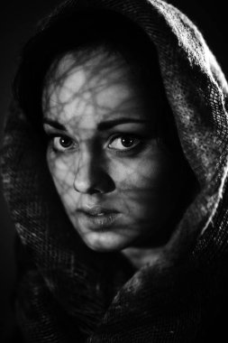 Güzel korkmuş kadın siyah arka plan üzerine bir atkı sarılı. Tek renkli fotoğraf, sanat gürültü