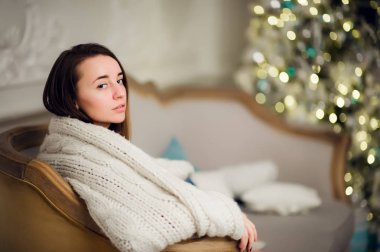 Noel tatili için bekleyen bir yumuşak ekose güzel genç kız. Xmas ağacı arka plan üzerinde