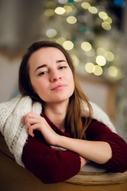 Gülümseyen güzel kadın Noel ağacı üzerinde arka plan üzerinde oturan