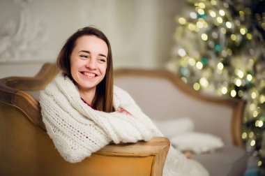 Noel tatili için bekleyen bir yumuşak ekose güzel genç kız. Xmas ağacı arka plan üzerinde