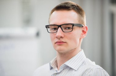 Casual gömlek ve gözlük işyerinde düşünceli genç adam portresi