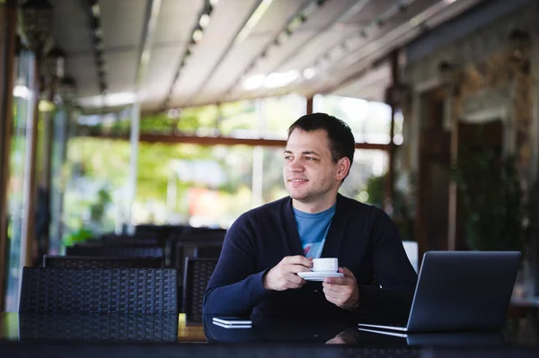 Красивий чоловік п'є еспресо в кавовому барі на відкритому повітрі . — стокове фото