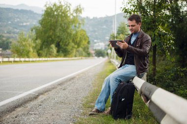 Gps tablet pc ile bir yol çit oturan ve online haritalar kullanarak adam