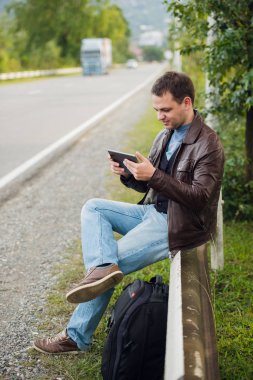 Gps tablet pc ile bir yol çit oturan ve online haritalar kullanarak adam