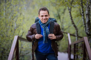 Sırt çantası ile seyahat mutlu bir genç adam portresi kapatın.