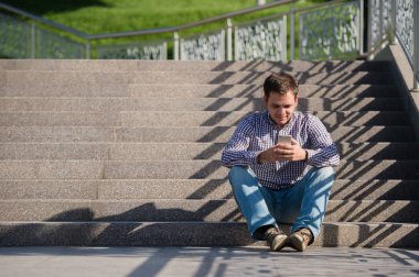 insanlar, Stil, teknoloji ve yaşam tarzı - City merdivenlerde oturan smartphone ile genç adam