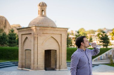 yakışıklı adam bir parkta şişe kaynak suyu içme