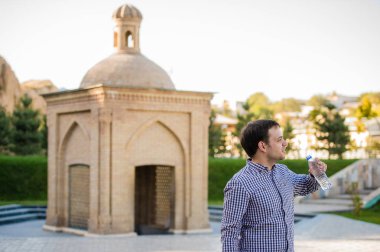 yakışıklı adam bir parkta şişe kaynak suyu içme