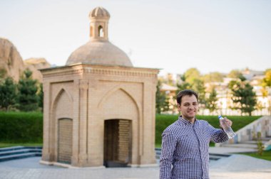 yakışıklı adam bir parkta şişe kaynak suyu içme