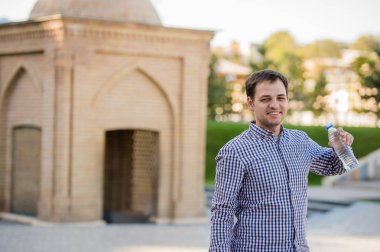 yakışıklı adam bir parkta şişe kaynak suyu içme