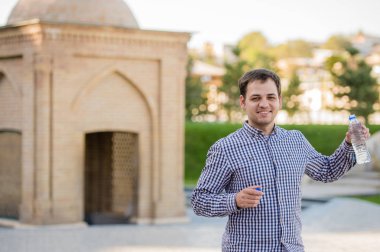 yakışıklı adam bir parkta şişe kaynak suyu içme