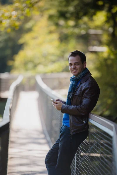 Guapo joven hipster feliz usando el teléfono inteligente — Foto de Stock