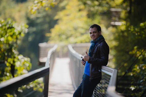 Hombre joven con dispositivo de vapeo de modo caja personalizada vapeando un cigarrillo electrónico al aire libre en un hermoso lugar al aire libre — Foto de Stock