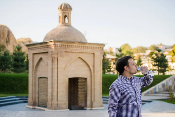 yakışıklı adam bir parkta şişe kaynak suyu içme