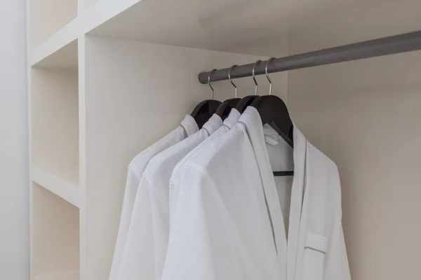White robes with wooden hangers at dressroom. — Stock Photo, Image