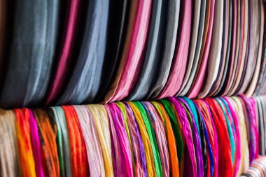 Renkli kumaşlardan oluşan geniş bir raf.