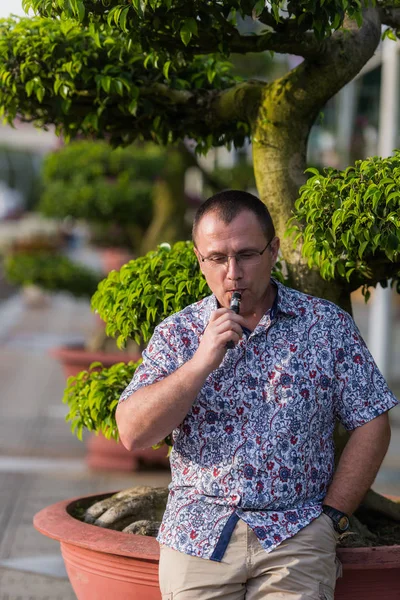 Дорослий старший чоловік паріння електронної сигарети на відкритому повітрі — стокове фото