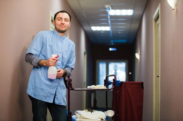 Homme nettoyage hall d'hôtel vêtu d'un manteau bleu — Photo