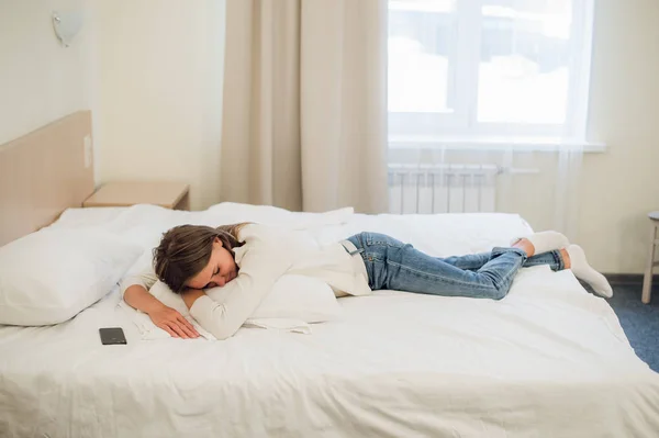 Relajada joven bonita mujer durmiendo en la cama con pantalla en blanco teléfono móvil —  Fotos de Stock