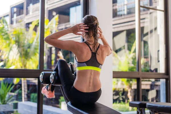 Portrét atletické ženy dělá cvičení cvičit břišní svaly ležící v tělocvičně v luxusní hotel v létě — Stock fotografie
