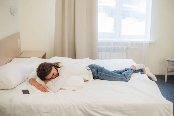 Relajada joven bonita mujer durmiendo en la cama con pantalla en blanco teléfono móvil — Foto de Stock