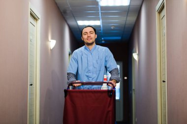 Genç yakışıklı iterek temizlik arabası - otel görüntüleri bir dizi.