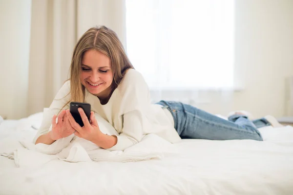 Retrato de una mujer feliz en su hermoso dormitorio mensajes de texto — Foto de Stock