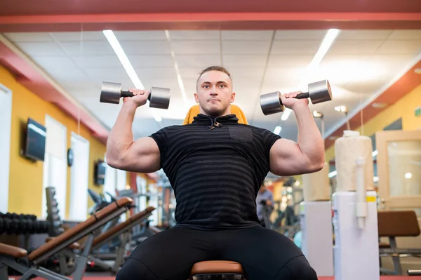 Jóképű sportos férfi súlyzó váll nyomja meg a feladatot. A tökéletes izmok erős testépítő. — Stock Fotó