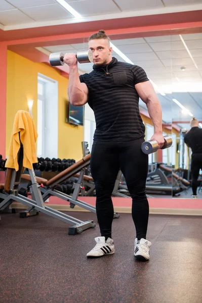 L'uomo forte in palestra che fa esercizi di bicipiti — Foto Stock