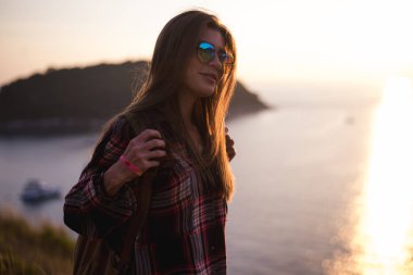 Genç şık hippi kız bakış açısı üzerinde günbatımı keyfini çıkarın. Sırt çantası kadınla seyahat