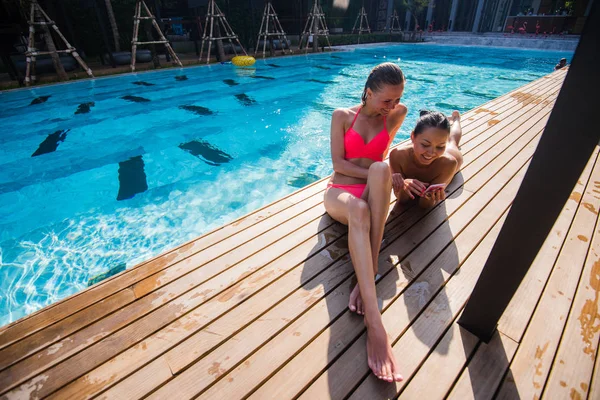 Dos hermosas chicas tomando una selfie al lado de la piscina —  Fotos de Stock