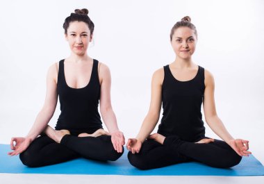Genç adam ve konumda lotus beyaz arka plan üzerinde izole meditasyon ve yoga yapıyor kadın.