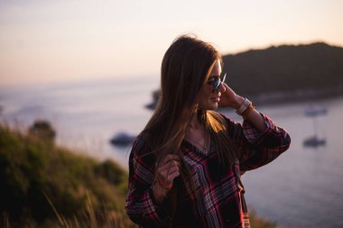 Genç şık hippi kız bakış açısı üzerinde günbatımı keyfini çıkarın. Sırt çantası kadınla seyahat
