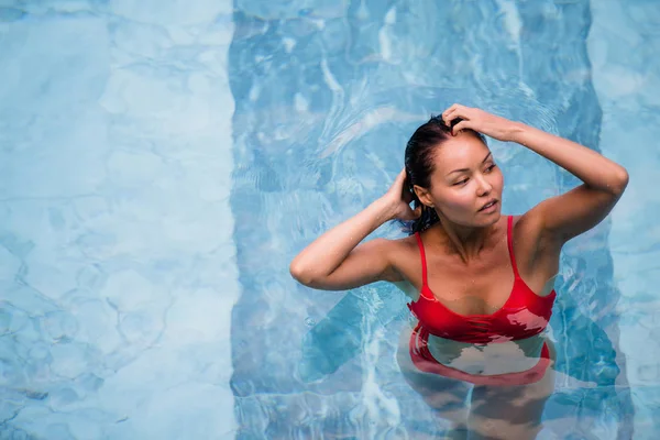 Disfrutando las vacaciones. Sonriente hermosa mujer joven en la piscina . — Foto de Stock